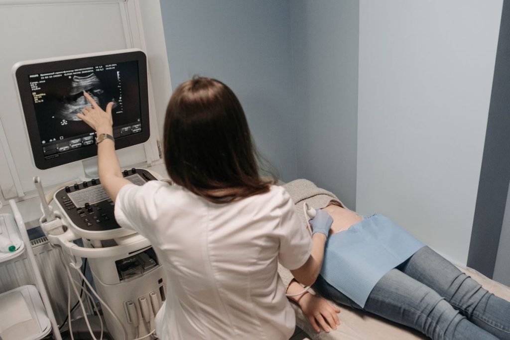 Female doctor conducting an ultrasound screening on a patient in a medical office.